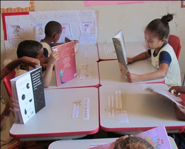 Atividades do projeto Comer Bem Faz Bem Crianças leem livros em uma sala de aula